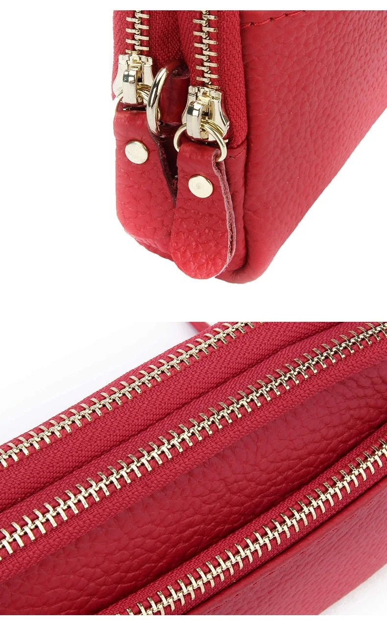 Close-up of a red genuine cowhide leather double-zip wristlet wallet showing the stitching and hardware.