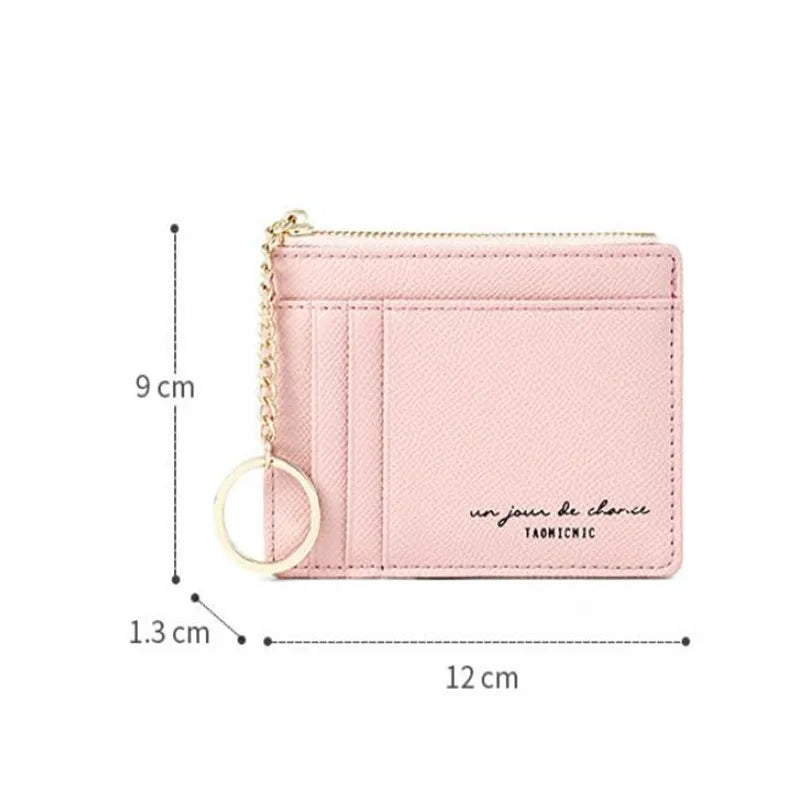 A pink compact PU leather zip wallet with a gold chain keychain shown from the side.