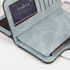 A light blue card holder wallet with a dark brown leather accent and a zippered closure is shown on a white surface.