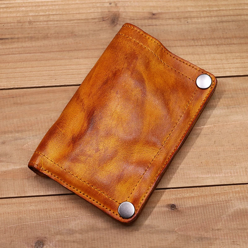 Braunes Leder-Bifold-Wallet mit silbernen Schnallen auf einer Holzoberfläche.