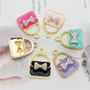 Un set de six charms en alliage émail de cristal aux couleurs et designs variés, y compris rose, vert menthe, or et violet.