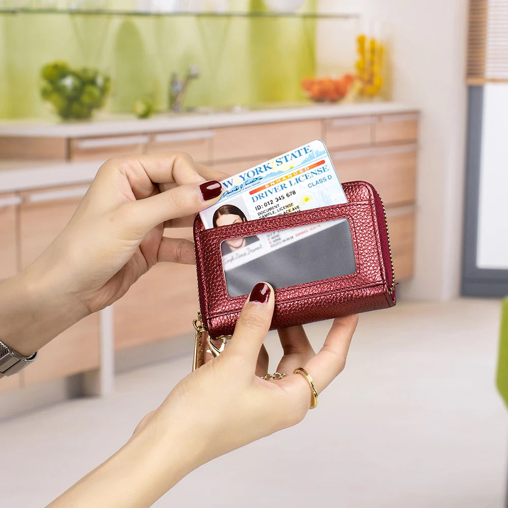 Una mano sostiene una cartera de billetera con funda de cuero granate que muestra una licencia de conducir del estado de Nuev