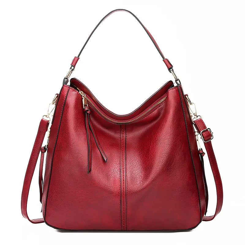 A deep red vintage faux leather hobo shoulder bag with gold hardware.