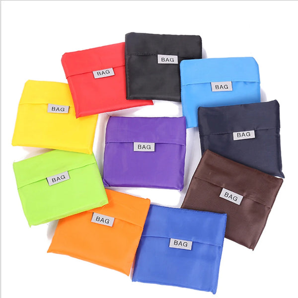 A collection of colorful, foldable shopping bags in various shades including red, yellow, green, purple, blue, and black.