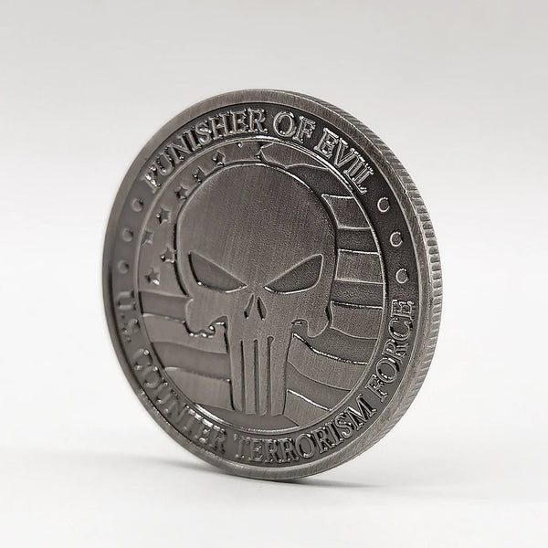 A round, dark silver commemorative coin featuring a stylized skull and crossbones design.