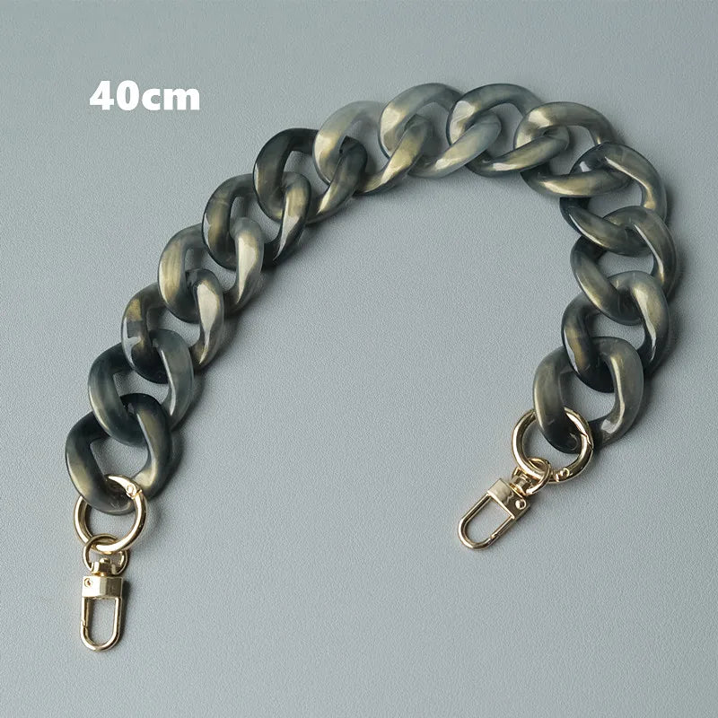 Bolso de cadena de resina plateada de 40 cm con cierre, mostrado contra un fondo gris.