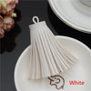 White leather tassel fringe craft supplies set displayed on a white plate.