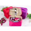 A pink quilted cosmetic storage box is open, revealing various makeup and toiletries inside.