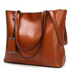 A brown waxed leather bucket bag with dual straps shown from the side.