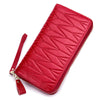 A vibrant red genuine leather RFID women's travel wallet with a quilted pattern and zipper closure.
