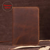 A brown genuine leather passport wallet with card holders resting on a dark surface.