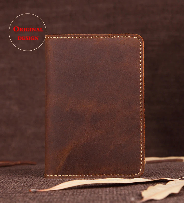 A brown genuine leather passport wallet with card holders resting on a dark surface.