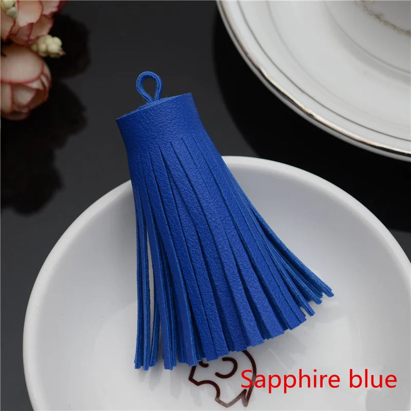 A vibrant sapphire blue leather tassel fringe craft supply set displayed on a white plate.