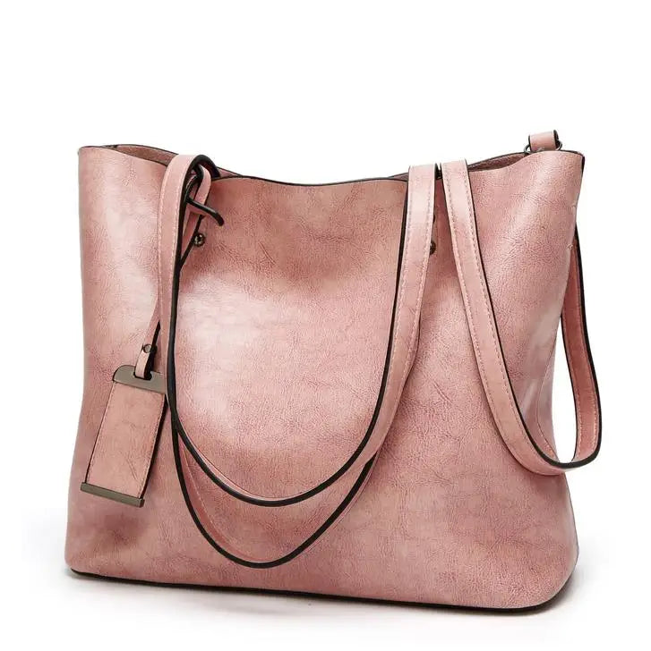 A dusty rose waxed leather bucket bag with dual straps shown from the front.