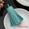 A teal leather tassel fringe craft supply set displayed on a white plate.