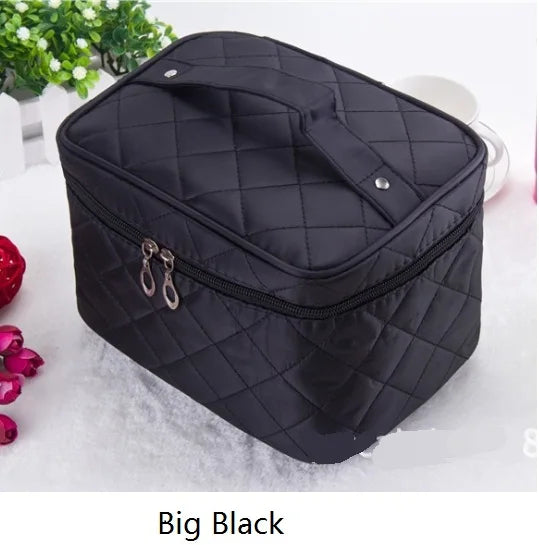 A black quilted cosmetic storage box with a zipper and hanging loops is shown on a white surface.
