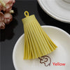 A yellow leather tassel fringe craft supply set resting on a white plate.