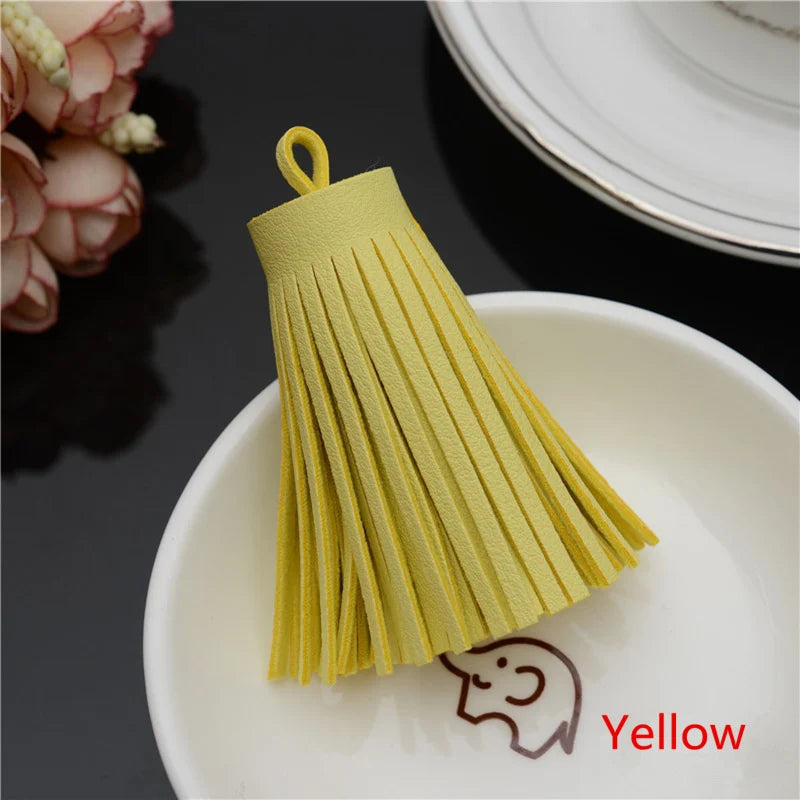 A yellow leather tassel fringe craft supply set resting on a white plate.