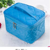 A blue quilted cosmetic storage box with a silver clasp is shown on a white surface.
