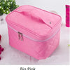 A pink quilted cosmetic storage box with a zipper and hanging charm is shown on a white surface.