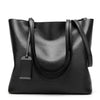 A black waxed leather bucket bag with dual straps shown from the front.
