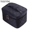 A black quilted cosmetic storage box with a zipper and hardware.