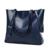 A dark navy waxed leather bucket bag with dual straps shown from the front.