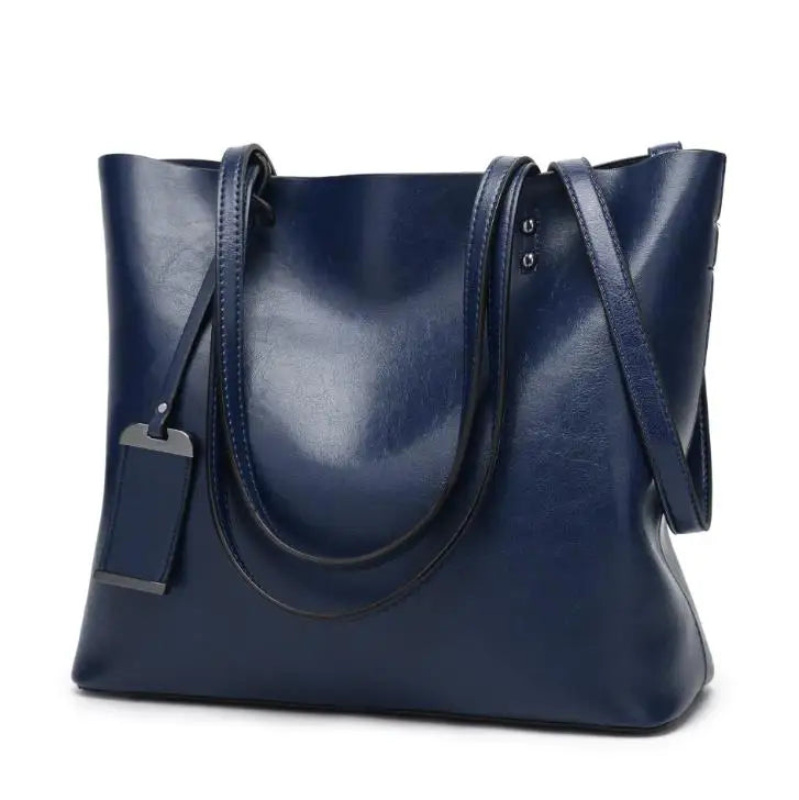 A dark navy waxed leather bucket bag with dual straps shown from the front.