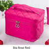 A bright pink quilted cosmetic storage box with a silver clasp resting on a white surface.