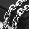 A close-up shot of a silver stainless steel rolo link chain necklace lying on a dark surface.