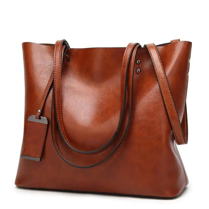 A brown waxed leather bucket bag with dual straps shown from the front.