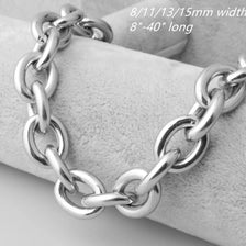 Silver stainless steel Rolo link chain necklace laid on a gray fabric background