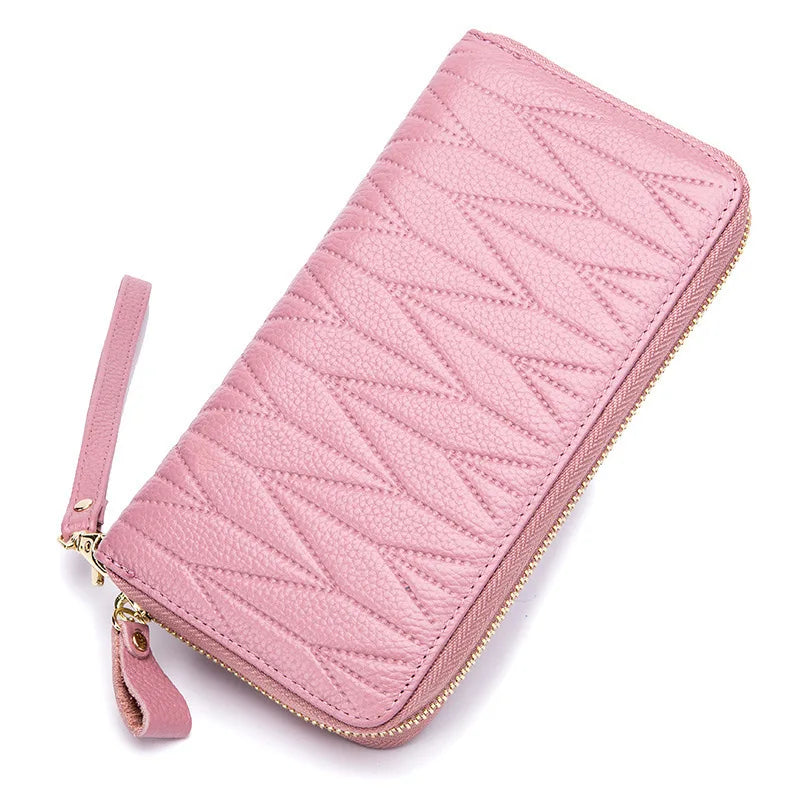 A pink quilted genuine leather RFID women's travel wallet with a zipper closure.