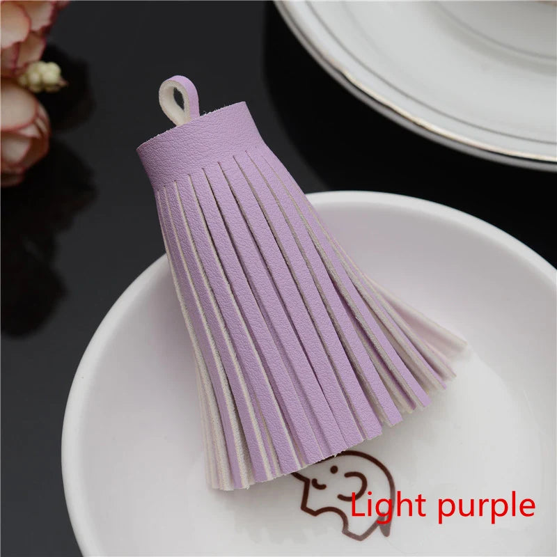 A purple leather tassel fringe craft supplies set displayed on a white plate.
