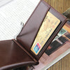 A brown leather wallet with an ID card visible inside, resting on a wooden surface.