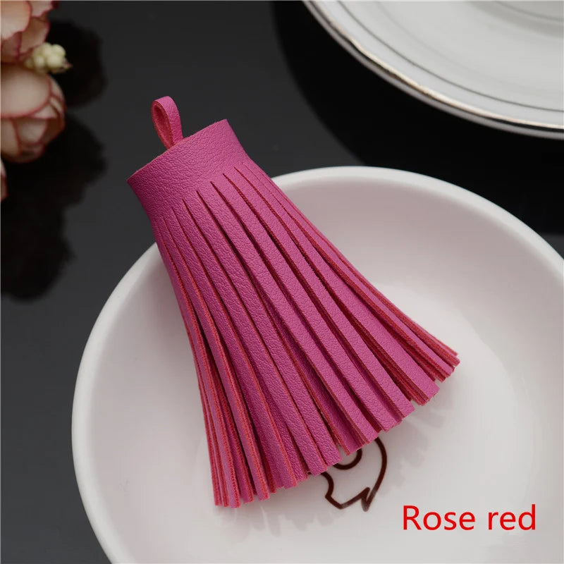 A pink leather tassel fringe craft supply set resting on a white plate.