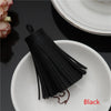 A black leather tassel fringe craft supplies set resting on a white plate.