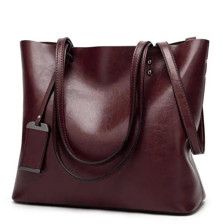 A deep burgundy waxed leather bucket bag with dual straps shown from the front.