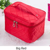 A red quilted cosmetic storage box with a zipper and hardware resting on a white surface.