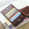 A brown leather money clip wallet is shown open, displaying several cards and cash inside.