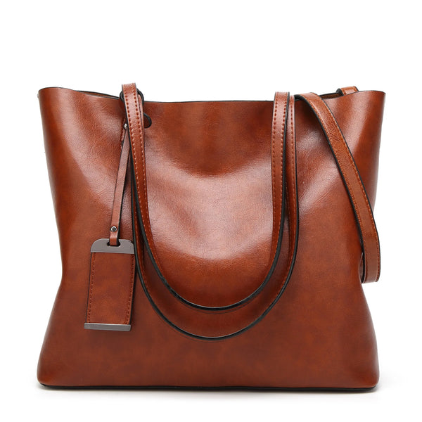 A brown waxed leather bucket bag with dual straps shown from the front.