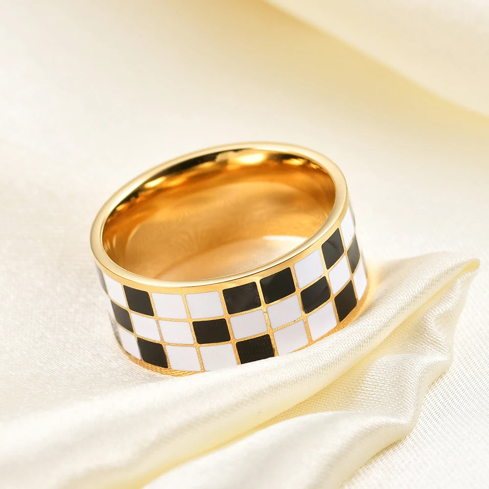 Gold dome rings featuring a black and white checkerboard pattern set against a cream fabric background