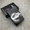A black cigarette case with a custom engraved design of a dog's head on a gray textured background.
