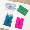 Three plastic card sleeves in various colors, including purple, green, and pink, are displayed on a white page.