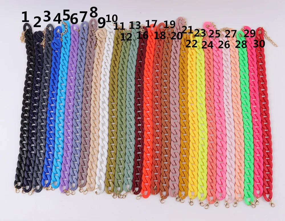 A display of colorful acrylic link chain necklaces in various shades including blue, purple, white, green, and pink.