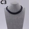A black acrylic link chain necklace displayed on a mannequin neck.