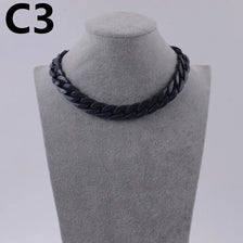 A black acrylic link chain necklace displayed on a mannequin neck.