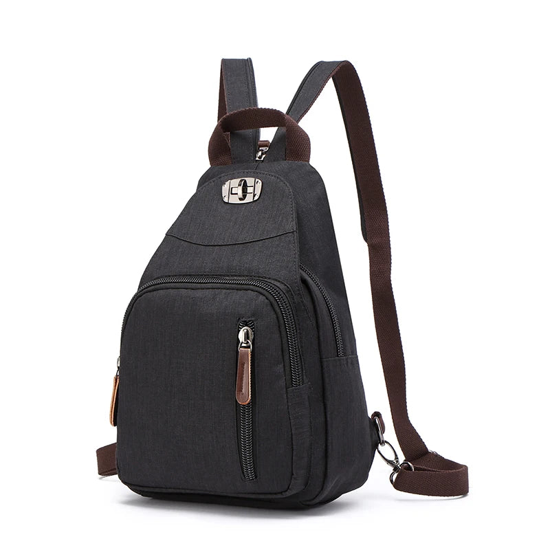 A dark gray canvas backpack with brown straps and a zippered pocket is shown from the back.