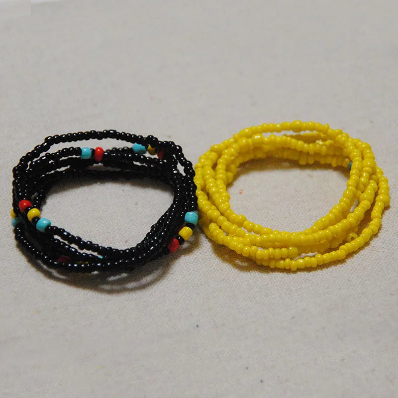 Two strands of colorful belly bead chains, one black and multi-colored, and one yellow.