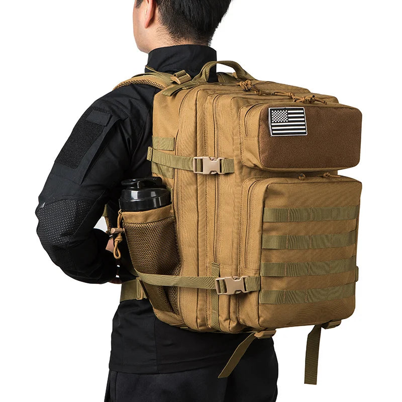 A tan tactical backpack with a black shirt and American flag patch visible on the front.
